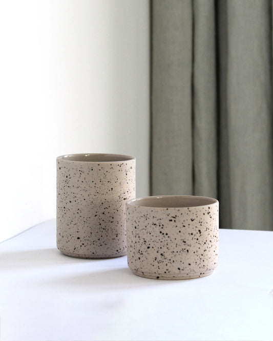 Forme Collection coffee mug in sand and speckled finish on a styled table setting