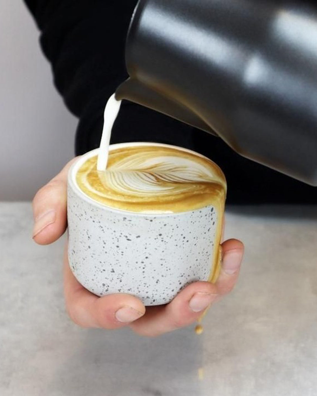 Cappuccino mug Fundament in light grey speckled and white by Archive Studio, filled with cappuccino by Barista Essentials