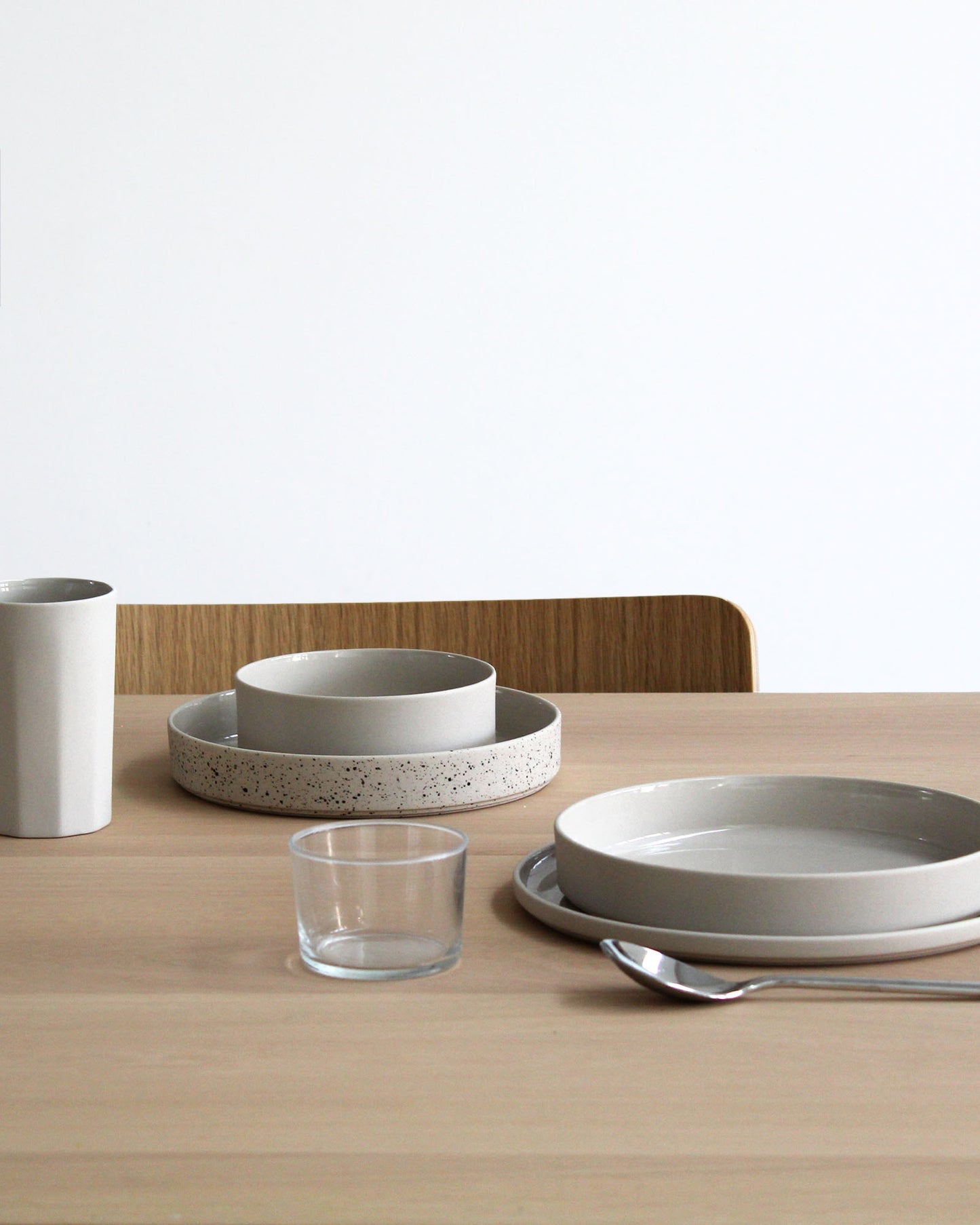 Forme Collection large stoneware plate in sand tone, styled on a modern table setting, glazed inside and unglazed outside