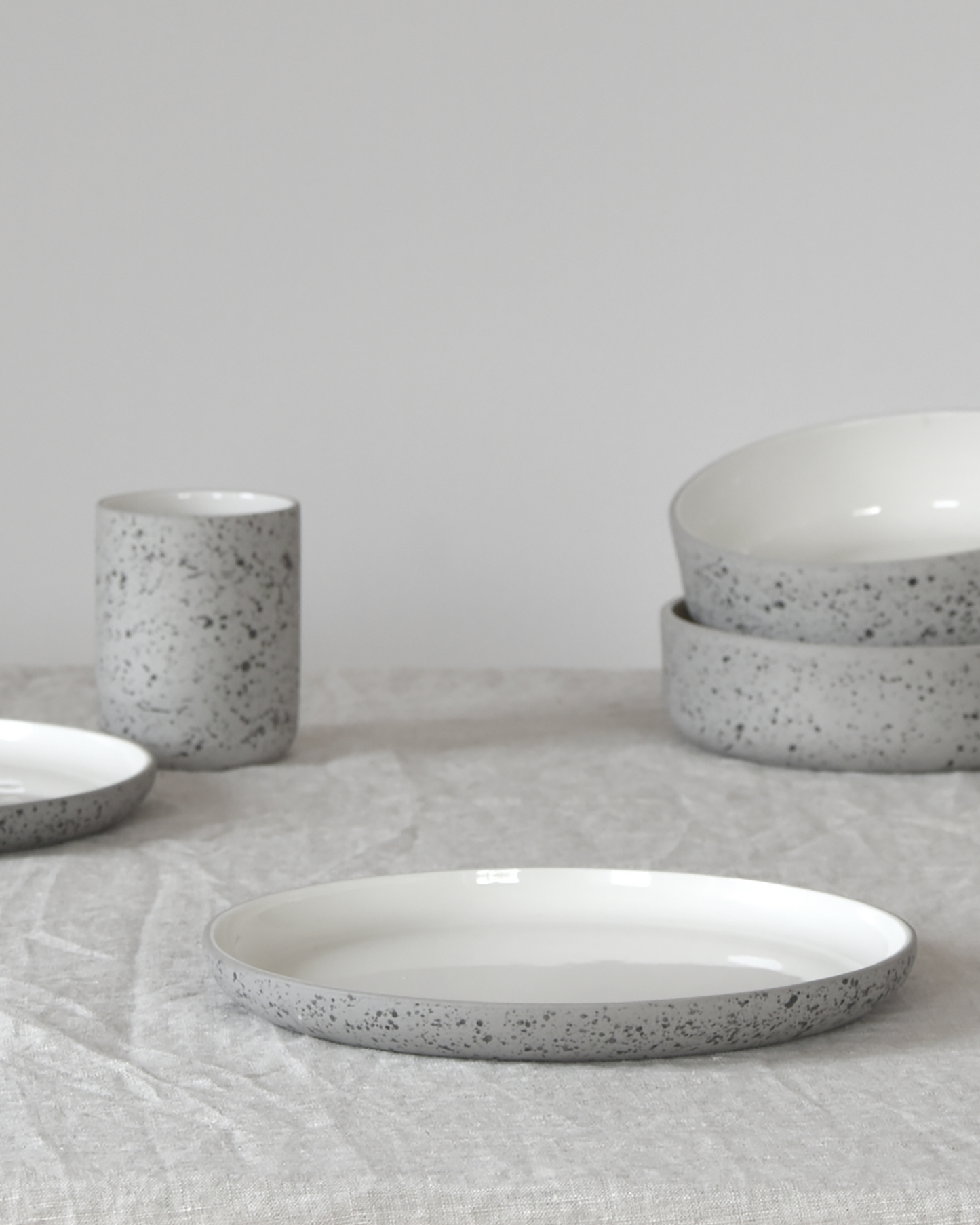 Minimalist light grey speckled/white bowl by Archive Studio on table