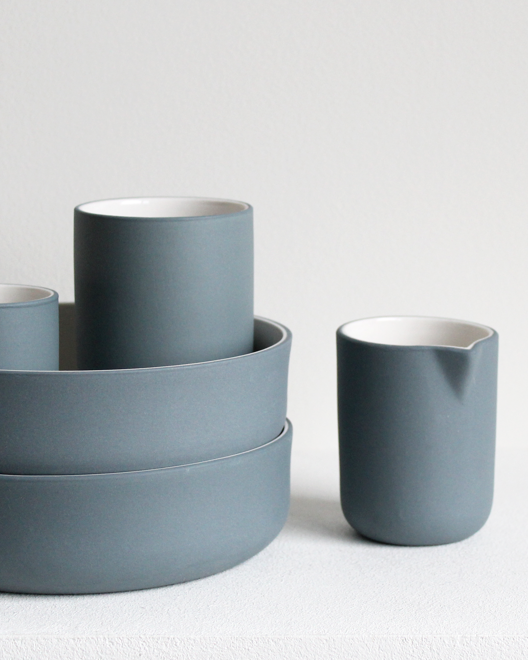 Minimalist teal/white bowl by Archive Studio on table